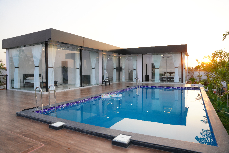 The Castro Glass Bedroom Farmhouse Koheda Hyderabad — outdoor pool, lawn and campfire on SpotLet